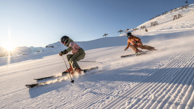 Skifahrer auf sonnigen Pisten im Schnee